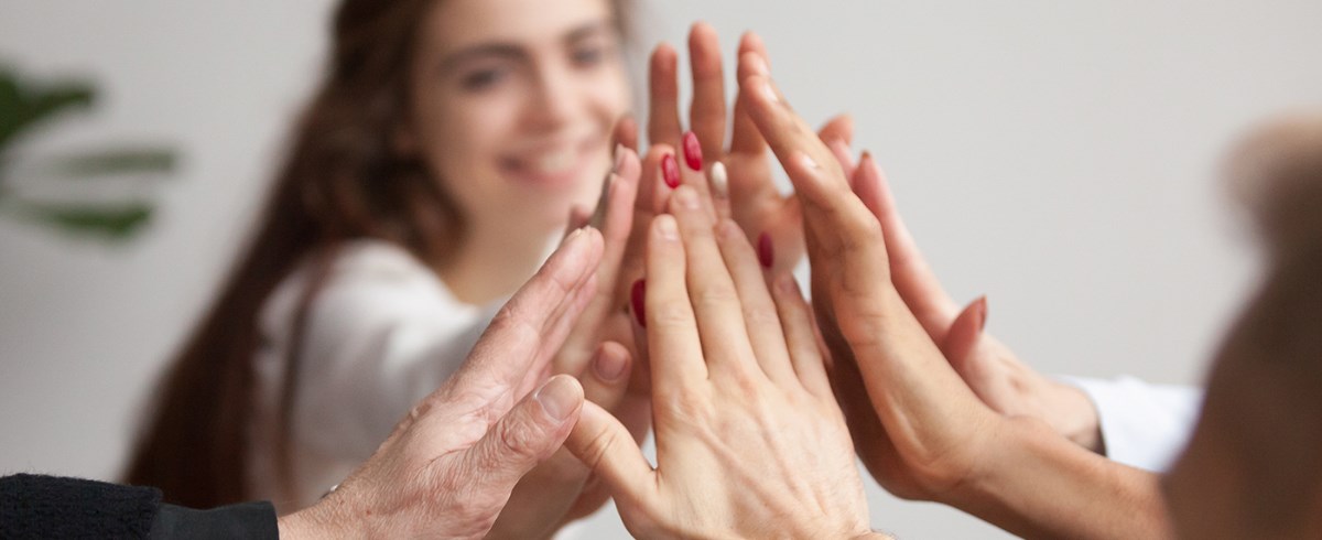 Meerdere handen raken elkaar als symbool voor samenwerking en verbondenheid.