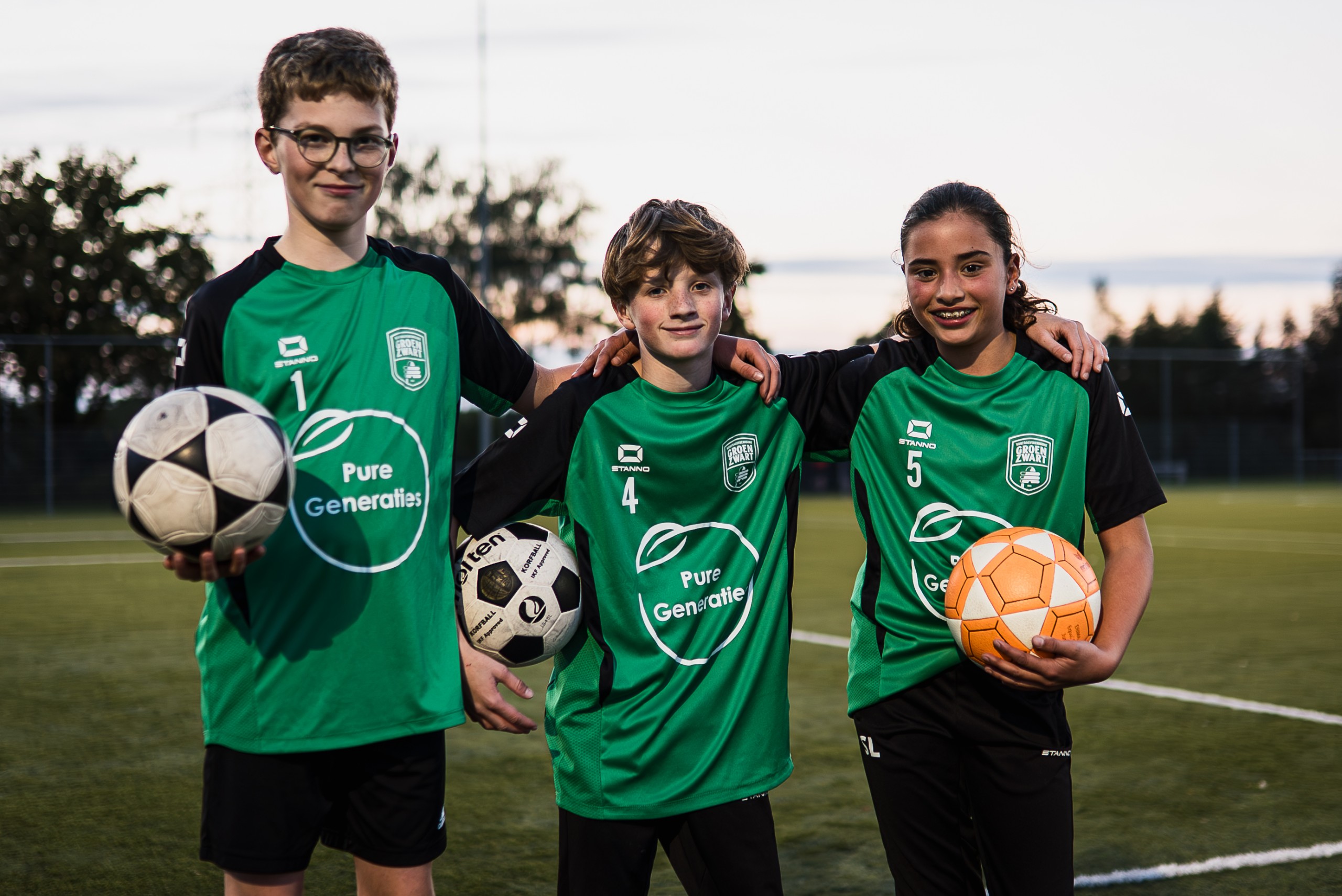 Jeugdspelers van Groen Zwart op het voetbalveld in groene wedstrijdshirts.