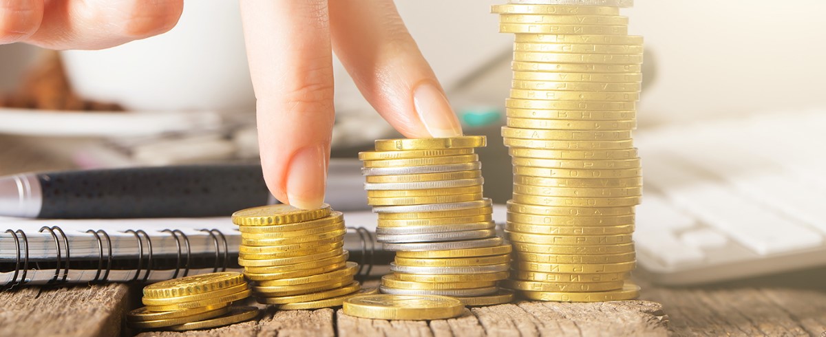 Stapels munten die financiële groei en vermogensopbouw symboliseren.