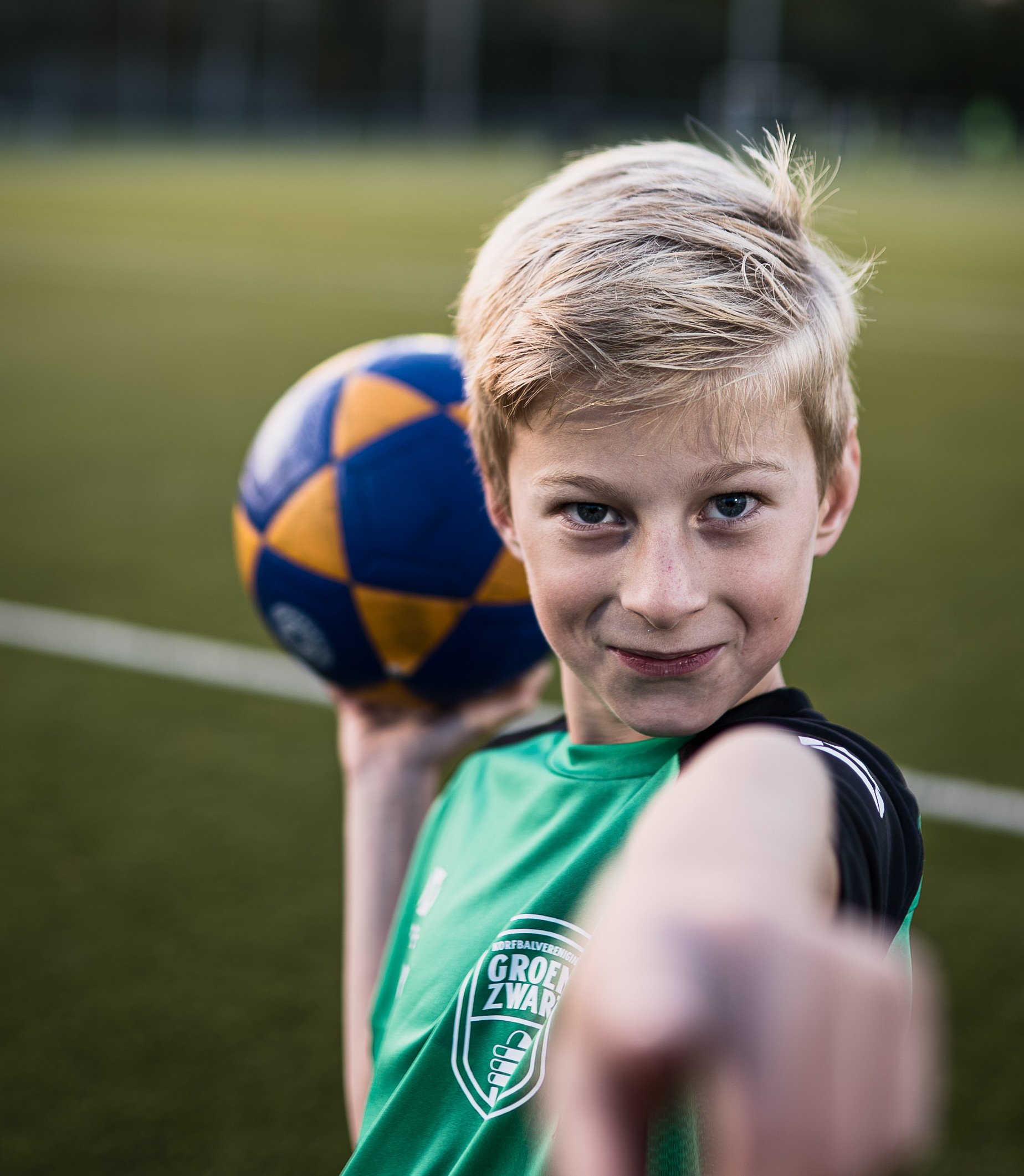 Jeugdspeler Groen Zwart Jeugdspeler van Groen Zwart op het voetbalveld met een bal in de hand.
